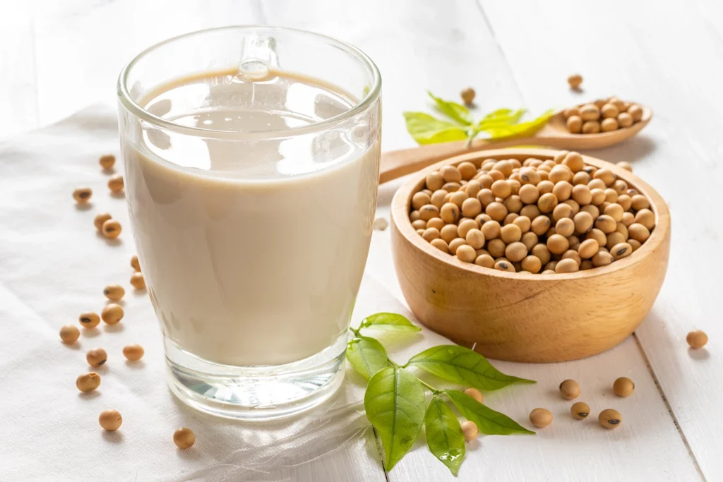 Bevanda vegetale di soia accanto a fagioli di soia – alternativa al latte vaccino
