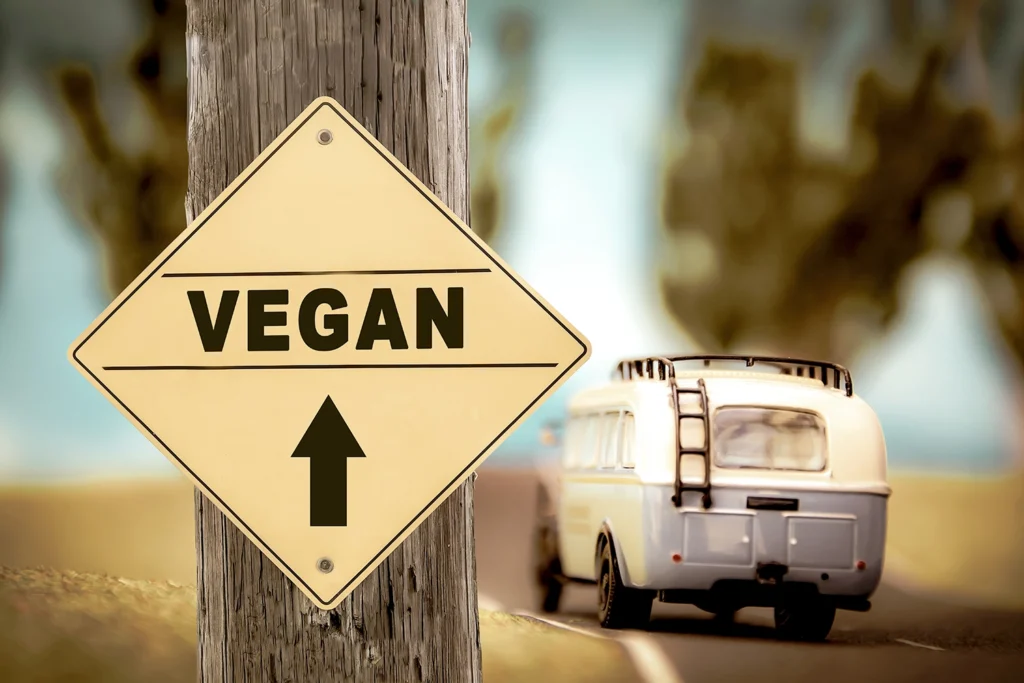 Cartello stradale con la scritta "Vegan" e freccia verso l’alto, simbolo di direzione etica e scelta consapevole, perfetto per un articolo su frasi sul veganismo.