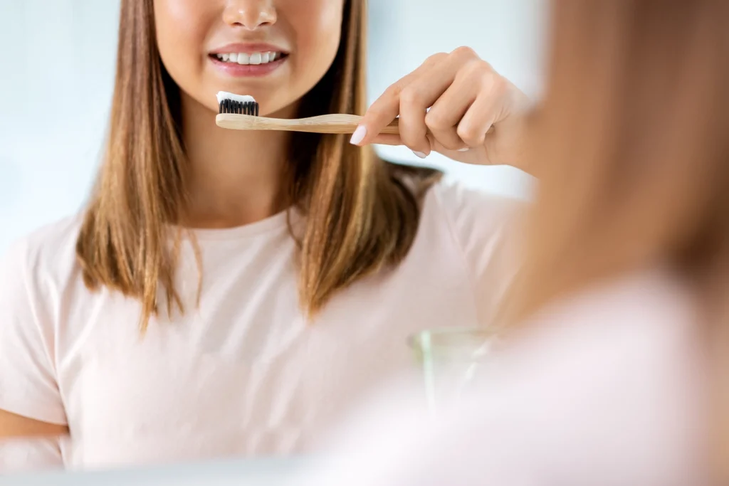 Ragazza sorridente che usa uno spazzolino sostenibile con dentifrici vegani e cruelty free