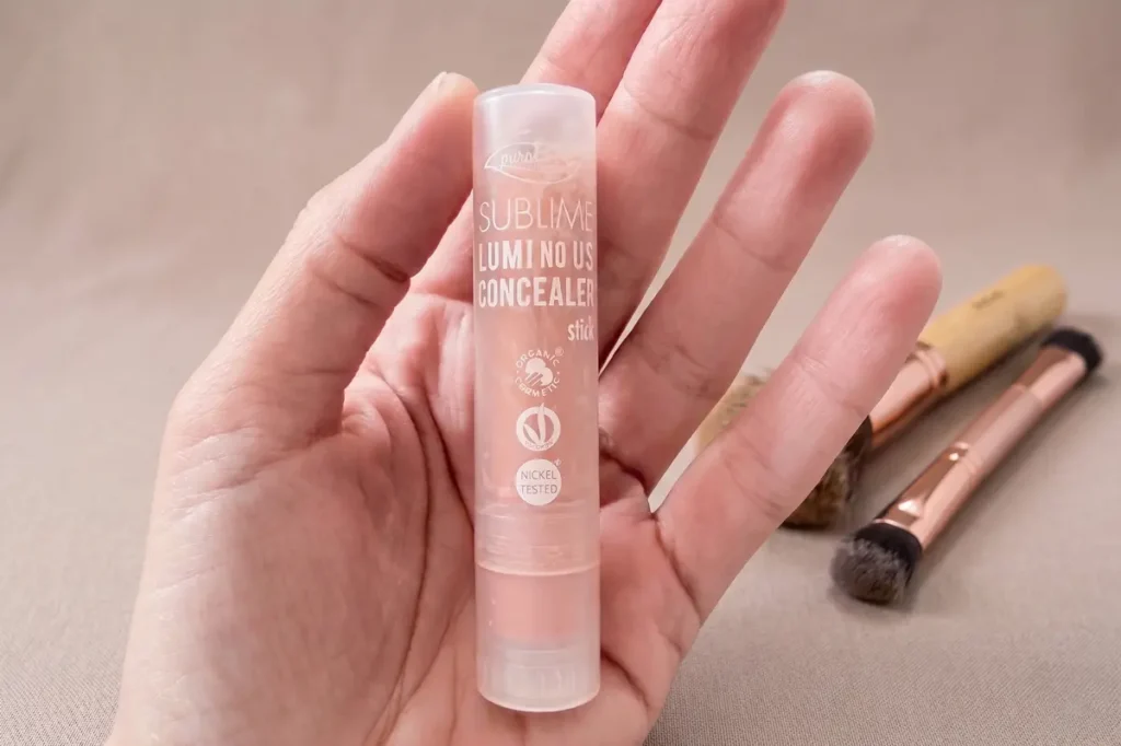 Sublime Luminous di PuroBio, correttore vegano stick in mano con packaging trasparente
